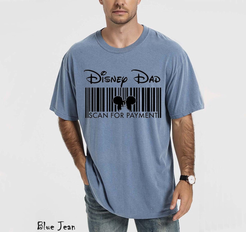 K&ouml;nnte beinhalten: Hellblaues T-Shirt mit dem Text "Disney Dad" &uuml;ber einem Barcode-Design. Der Barcode enth&auml;lt eine Silhouette von Mickey Mouse-Ohren und die Worte "SCAN FOR PAYMENT".