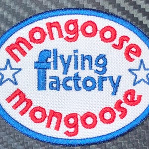 May include: Oval patch with the words "mongoose" in red, arched around the top and bottom. The words "flying factory" are in blue in the center. Two blue stars flank the center text. The patch has a blue border.