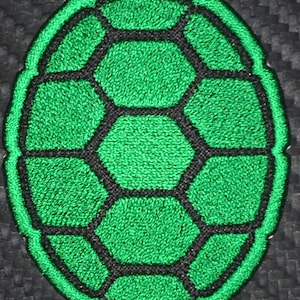 May include: Green embroidered turtle shell patch with black stitching.