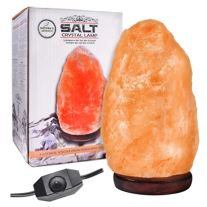 May include: A natural Himalayan salt crystal lamp with a warm orange glow. The lamp is on a wooden base and has a cord with a switch. The box reads "Salt Crystal Lamp" and "A Natural Ionizer from Himalayan Salt".