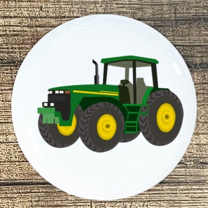 May include: A green and black tractor with yellow wheels on a white background.