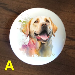 May include: A white ceramic knob with a watercolor painting of a golden retriever dog with a happy expression. The dog is surrounded by colorful watercolor splatters.
