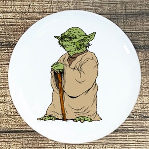 May include: A green and brown cartoon character with large ears and a long brown staff. The character is standing on a white background.