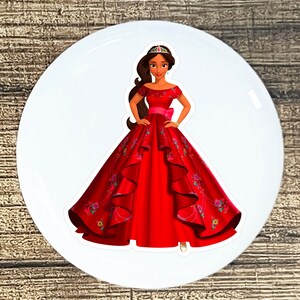 May include: A red princess dress with floral embroidery and a crown. The dress has a full skirt and a fitted bodice. The princess is wearing a crown and has long brown hair.