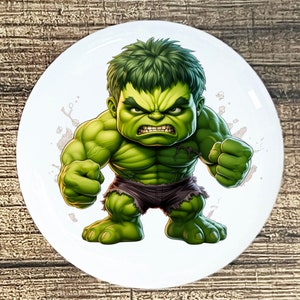 May include: A green cartoon Hulk character with a fierce expression, standing with his fists clenched. The background is white with a few splatters of paint.