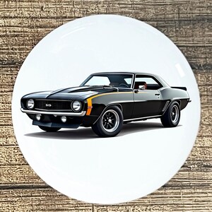 May include: Black classic car with orange and yellow racing stripes. The car has the SS emblem on the front. The car is on a white background.