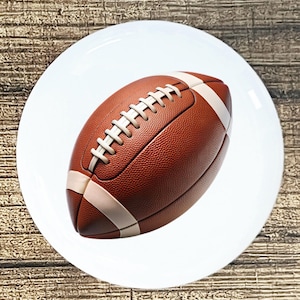 May include: A brown and white football with laces. The football is on a white background.