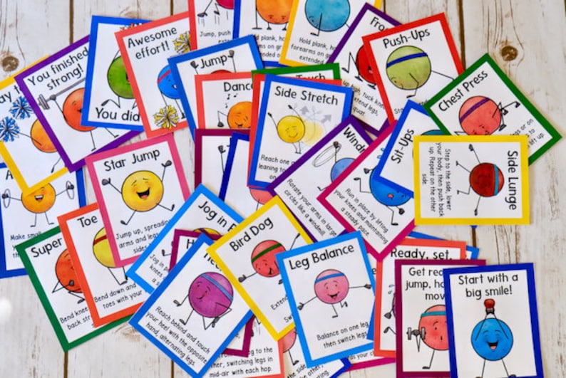 May include: Colorful cards with illustrations of cartoon characters performing different exercises. Each card has a title and instructions for the exercise. The titles include "Star Jump", "Side Lunge", "Push-Ups", "Sit-Ups", "Bird Dog", "Leg Balance", "Jog in Place", "Toe", "Super", "You Did", "Awesome Effort", "Jump", "Dance", "Side Stretch", "Windmills", "Chest Press", "Ready, Set, Get Ready", "Start with a Big Smile!" and "You Finished Strong!"