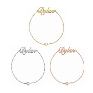 Può includere: Tre braccialetti con il nome "Dylan" su di essi, in oro, argento e oro rosa.
