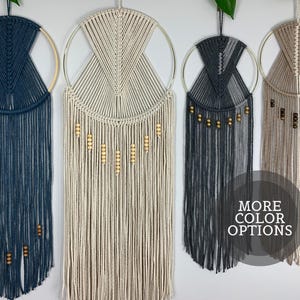 May include: A white ceramic mug with a black handle and the text "But First, Coffee" in a bold, black font. The mug is filled with a dark liquid, likely coffee, and sits on a light-colored surface.