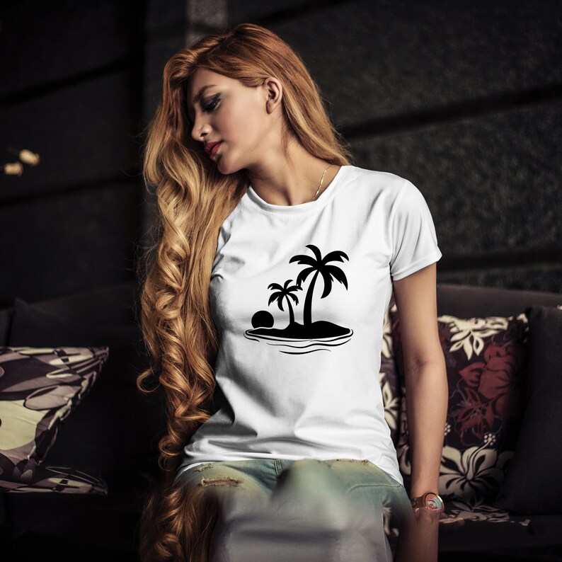 K&ouml;nnte beinhalten: Ein wei&szlig;es T-Shirt mit einer schwarzen Silhouette von Palmen auf einer Insel. Das Design beinhaltet eine Sonne und Wellen.