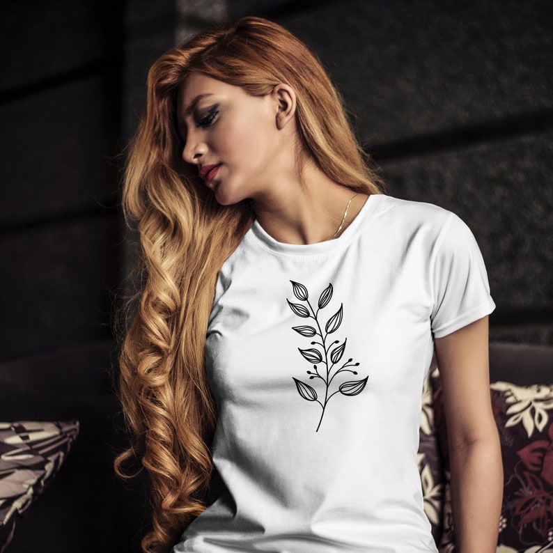 May include: A white t-shirt with a black floral design on the front. The design is a simple, stylized branch with leaves.