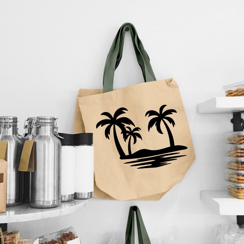 K&ouml;nnte beinhalten: Eine beige Tragetasche mit schwarzen Palmen-Silhouetten und einem schwarzen Wellendesign. Die Tasche hat gr&uuml;ne Henkel.
