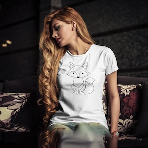 May include: A white t-shirt with a black line drawing of a fox on the front. The fox is sitting with its tail curled behind it.