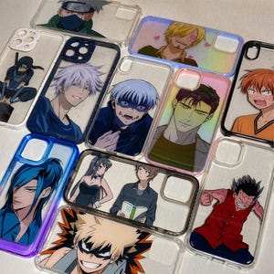 Pu&ograve; includere: Una collezione di custodie per telefono trasparenti con vari personaggi anime stampati su di esse. I personaggi includono un uomo biondo con un cappello di paglia, un uomo con i capelli blu, un uomo con i capelli verdi, un uomo con i capelli neri, una donna con i capelli neri, un uomo con i capelli castani, un uomo con i capelli rossi e un uomo con i capelli biondi. Le custodie sono tutte trasparenti e hanno un bordo bianco attorno all'immagine stampata.