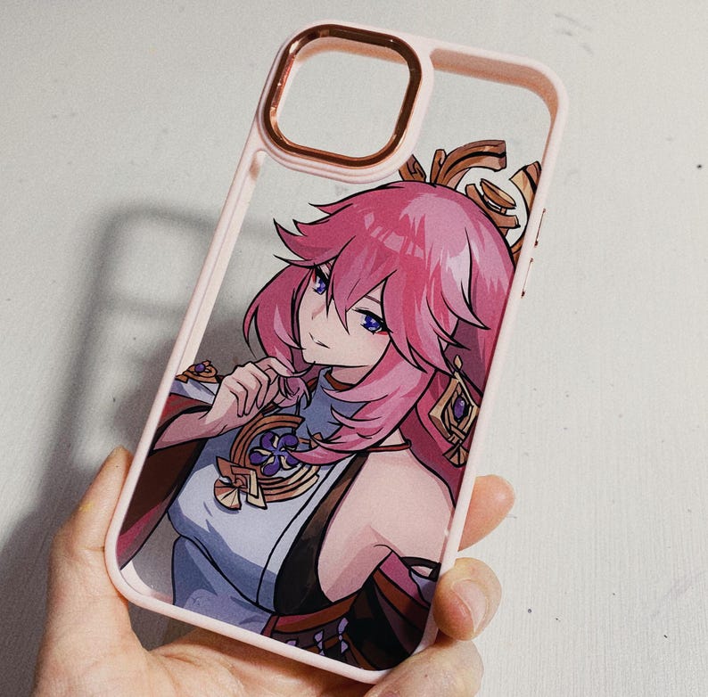 Pu&ograve; includere: Una custodia per telefono rosa con un design di personaggio anime colorato. Il personaggio ha i capelli rosa, gli occhi blu e indossa un abito bianco e dorato. La custodia &egrave; realizzata in plastica trasparente con un bordo rosa.