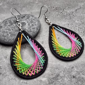 May include: A pair of teardrop-shaped earrings with a black base and colorful thread wrapped around the edges. The thread is in shades of pink, green, orange, and blue.