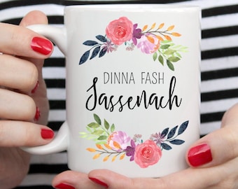 May include: White ceramic mug with a floral design and the text "Dinna Fash Sassenach".