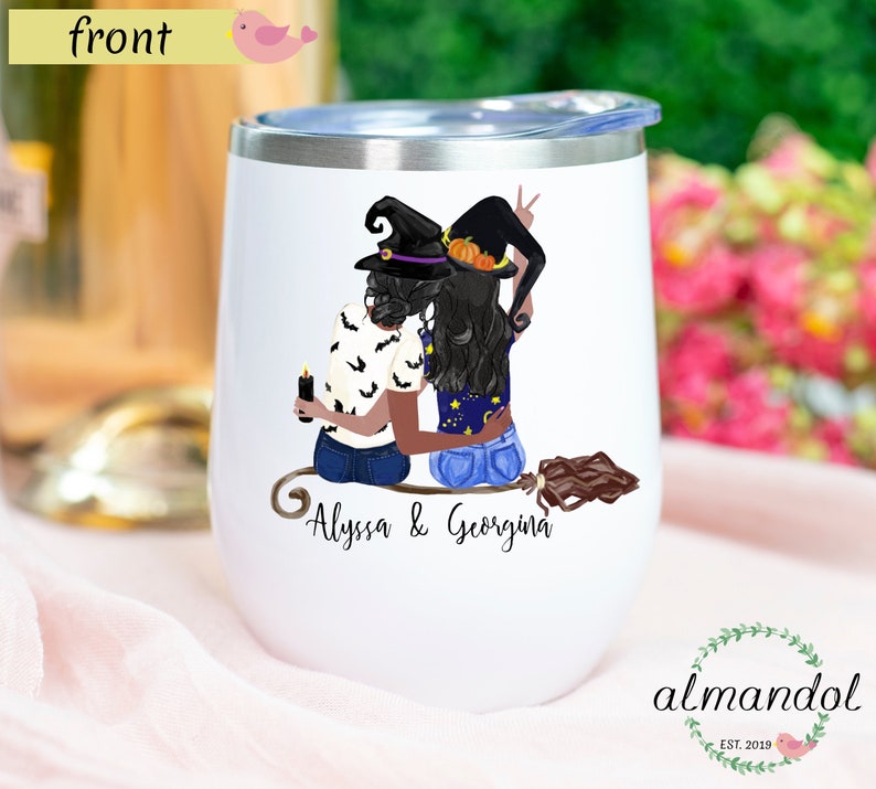 May include: White stainless steel tumbler with a black and white illustration of two women dressed as witches on a broomstick. The text "Alyssa & Georgina" is printed below the illustration.