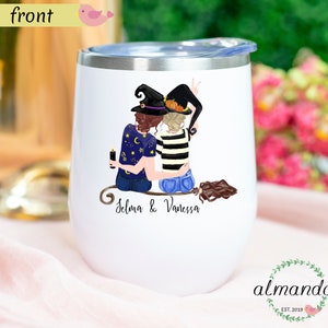 May include: White stainless steel wine tumbler with a graphic of two witches wearing black hats and holding a broom. The text "Selma & Vanessa" is printed below the graphic.