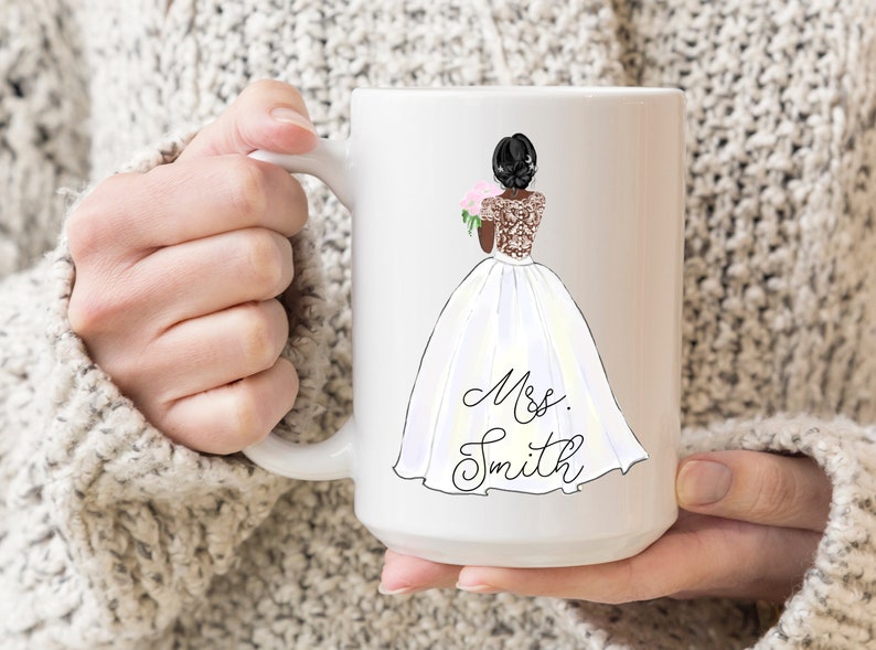 Pu&ograve; includere: Tazza in ceramica bianca con un'illustrazione in bianco e nero di una sposa in abito da sposa bianco che tiene un bouquet di fiori rosa. Il testo "Mrs. Smith" &egrave; scritto in corsivo sotto la sposa.
