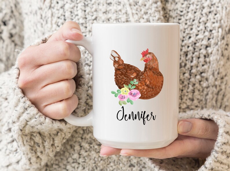 May include: White ceramic mug with a brown chicken illustration and pink and yellow flowers. The mug has the name "Jennifer" written on it.