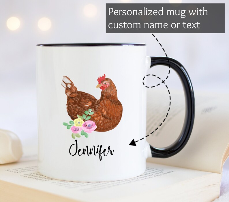 May include: White ceramic mug with a black rim and handle. The mug features a watercolor illustration of a brown hen with pink and yellow flowers. The name "Jennifer" is written in black cursive below the hen.