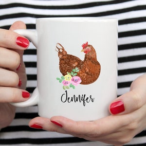 May include: White ceramic mug with a brown chicken illustration and pink and yellow flowers. The mug has the name "Jennifer" written in black cursive.
