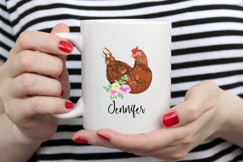 May include: White ceramic mug with a brown chicken illustration and pink and yellow flowers. The mug has the name "Jennifer" written in black cursive.