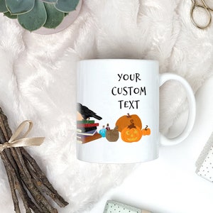 Pode incluir: Caneca de cer&acirc;mica branca com um corvo preto, uma pilha de livros, garrafas de po&ccedil;&otilde;es, uma ab&oacute;bora e o texto "YOUR CUSTOM TEXT".