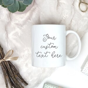 Pu&ograve; includere: Tazza in ceramica bianca con un messaggio scritto a mano in nero che dice "Your custom text here".