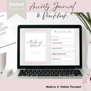 Puede incluir: Un ordenador portátil que muestra un diario y un cuaderno de trabajo para la ansiedad de color rosa y blanco con el texto "Este diario pertenece a" y "Hoy va a ser un gran día." El portátil está sobre una superficie blanca con una taza de café blanca y una planta verde en una maceta blanca. El texto "Descargas instantáneas" y "Diario de ansiedad y cuaderno de trabajo" están en la parte superior de la imagen. El texto "Hecho por un terapeute holístico" está en la parte inferior de la imagen.