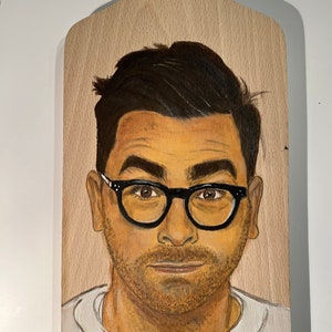 David Levy pintando sobre una tabla de madera
