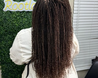 Pode incluir: Uma pessoa com longos dreadlocks castanhos. Os dreadlocks são estilizados em um estilo reto e fluente. A pessoa está vestindo uma camisa branca.