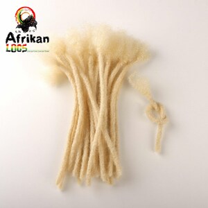 May include: A bundle of light blonde dreadlocks, arranged on a white surface. The dreadlocks are thick and textured, with a natural, slightly frizzy appearance. The image includes the text "Afrikan LOOS" with a logo featuring a woman's silhouette.