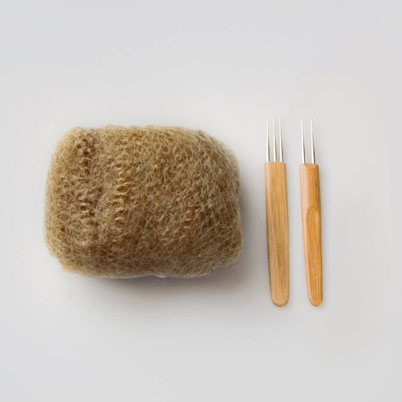 May include: A bundle of brown wool roving with two wooden knitting needles with metal tips.