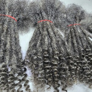 Op de afbeelding: Een bundel grijze, krullende dreadlocks haarverlengingen. Het haar is lang en dik, met een natuurlijke, licht golvende textuur.