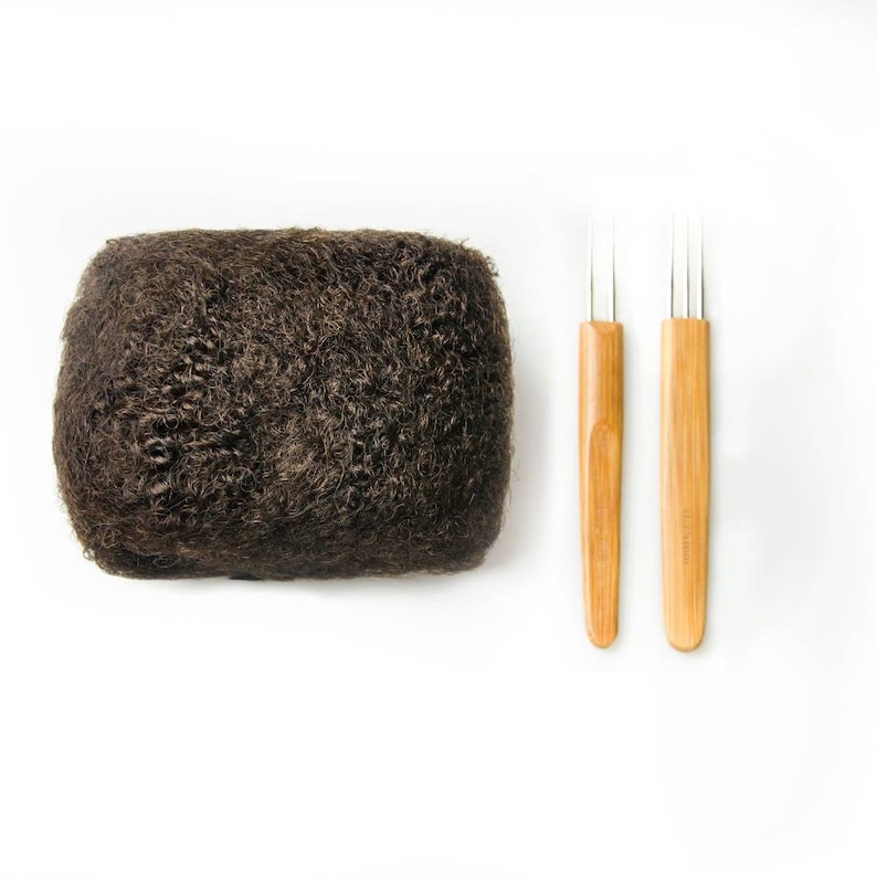 May include: A brown afro hairpiece with two wooden hair pick tools.