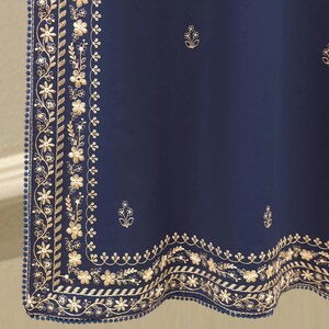 May include: A navy blue textile with intricate gold floral embroidery along the edges. The design includes detailed flowers, leaves, and a border of small blue beads. Scattered gold floral motifs are also present.