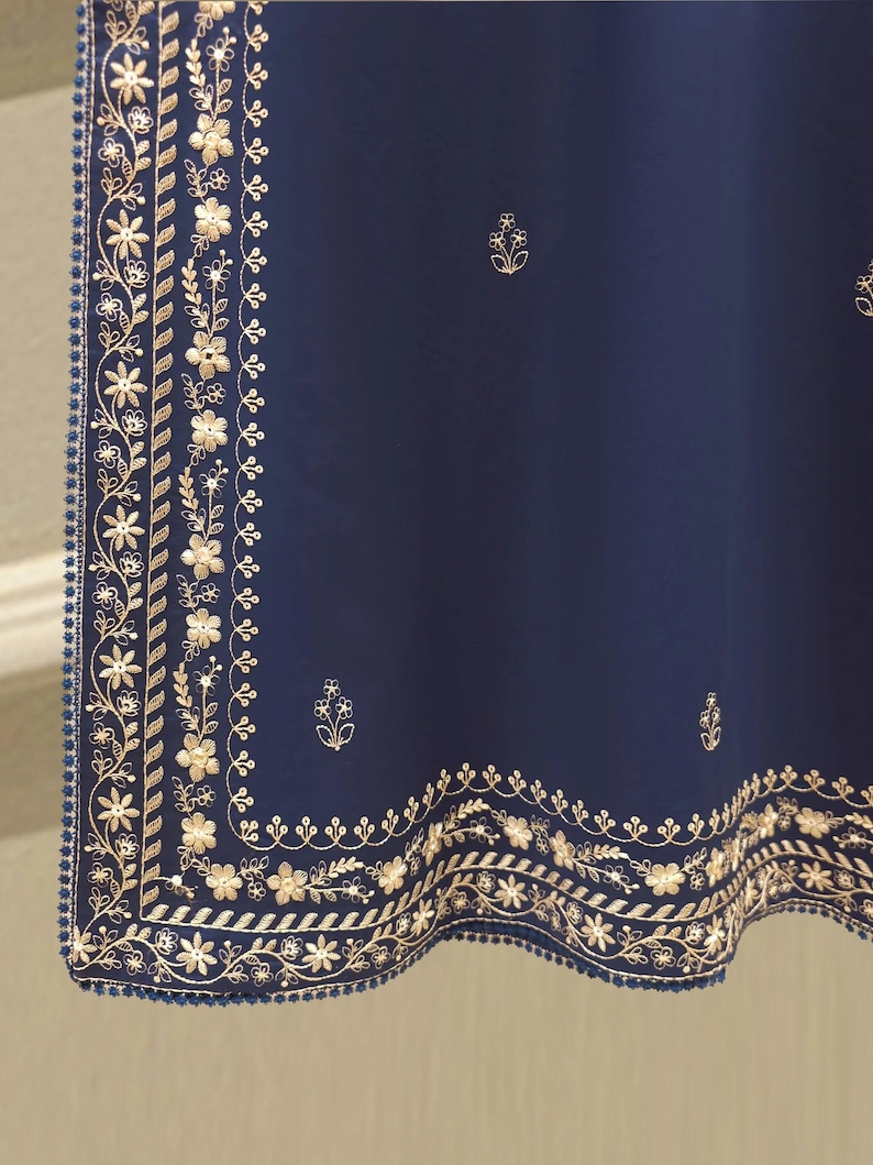 May include: A navy blue textile with intricate gold floral embroidery along the edges. The design includes detailed flowers, leaves, and a border of small blue beads. Scattered gold floral motifs are also present.