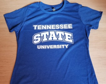 Peut inclure: Un t-shirt bleu avec du texte blanc qui dit "Tennessee State University".