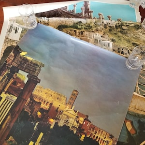 May include: A vintage poster featuring a photograph of the Roman Forum in Rome, Italy. The poster is in a muted color palette of browns, yellows, and blues. The image shows the ruins of the Forum, including the Colosseum, the Arch of Titus, and the Temple of Saturn.