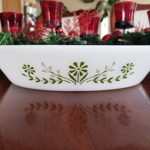 Peut inclure: Plat à four ovale blanc avec un motif floral vert. Le plat mesure environ 30 cm de long et possède un bord légèrement évasé. Le motif floral comprend des fleurs et des feuilles stylisées, pour servir des plats.