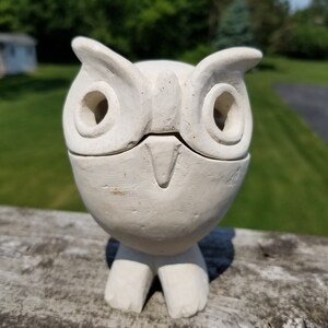 May include: White ceramic owl figurine with large eyes and a beak. The owl is standing on two feet.
