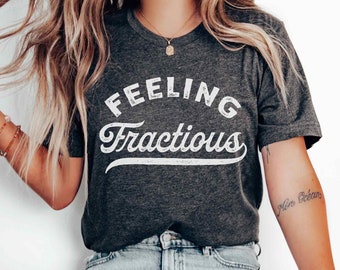 May include: A dark grey heather t-shirt with the text "Feeling Fractious" printed in white. The text is in a vintage style font.