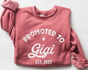 May include: Heather scarlet red sweatshirt with the text "Promoted to Gigi Est. 2025" in white.
