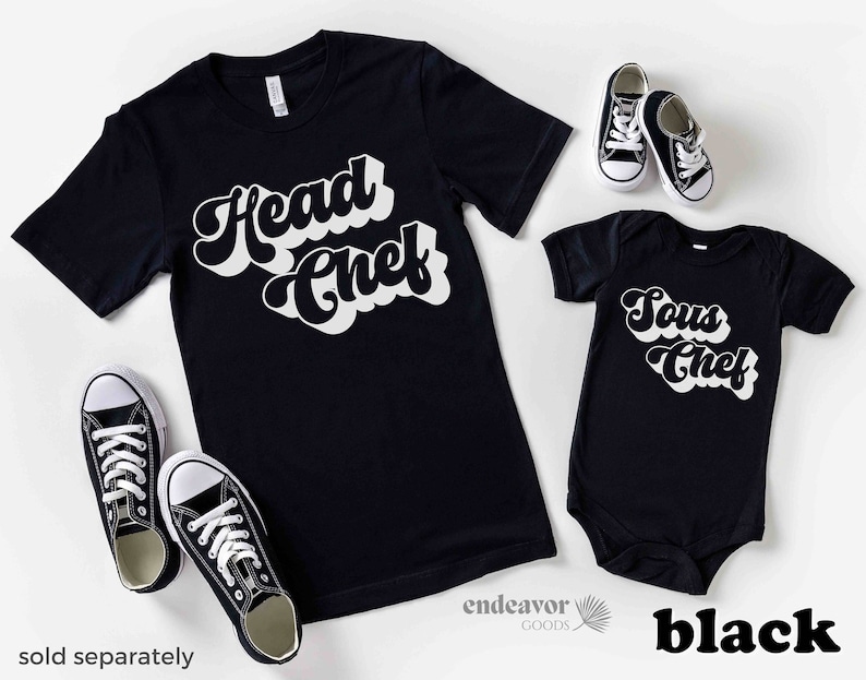 K&ouml;nnte beinhalten: Schwarzes T-Shirt mit wei&szlig;em Text "Head Chef" und ein schwarzer Body mit wei&szlig;em Text "Sous Chef". Beide Shirts haben einen Retro-Schriftart-Stil.