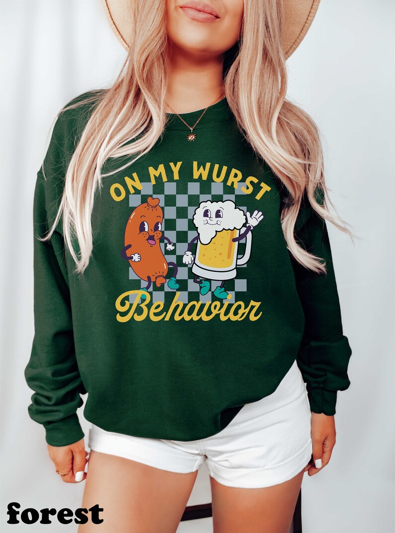 May include: Green sweatshirt with a white checkered background and a cartoon sausage and beer mug with the text "On My Wurst Behavior".