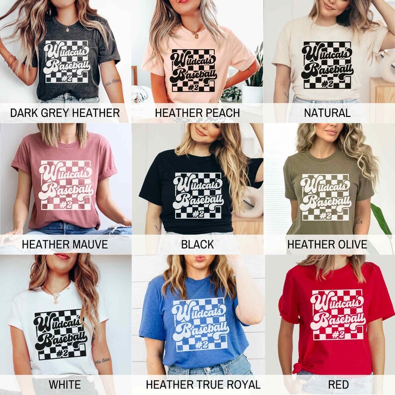 May include: A collection of t-shirts in various colors, each featuring the text "Wildcats Baseball #2" in a retro font within a checkered square. Colors include dark grey, peach, natural, mauve, black, olive, white, blue, and red.