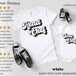 K&ouml;nnte beinhalten: Wei&szlig;es T-Shirt mit dem Text "Head Chef" in schwarzer Retro-Schrift. Wei&szlig;er Strampler mit dem Text "Sous Chef" in schwarzer Retro-Schrift.  "endeavor GOODS" ist in der oberen rechten Ecke des Bildes gedruckt.  "wei&szlig;" und "jedes Shirt separat verkauft" sind unten im Bild gedruckt.